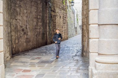 Karadağ 'ın eski Kotor kasabasında güneşli bir günde Renkli caddenin tadını çıkaran erkek turist. Karadağ 'a Seyahat