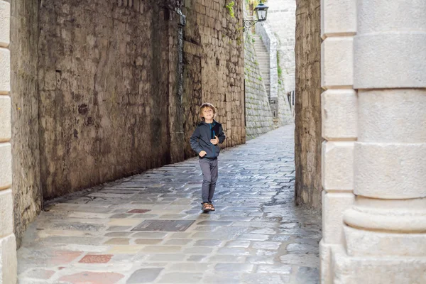 Boy tourist enjoying Colorful street in Old town of Kotor on a sunny day, Montenegro. Travel to Montenegro concept — ストック写真