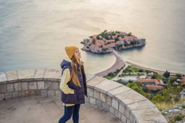 Karadağ 'ın Budva Riviera kentindeki St. Stephen adasının güzel manzaralı kadın turist Sveti Stefan. Karadağ 'a Seyahat