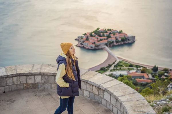Donna turista sullo sfondo della splendida vista dell'isola di Santo Stefano, Sveti Stefan sulla riviera di Budva, Budva, Montenegro. Viaggio in Montenegro concetto — Foto Stock