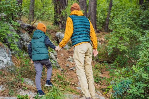 Baba ve oğul gezginler Kotor 'un manzarasından hoşlanırlar. Karadağ. Kotor Körfezi, Kotor Körfezi, Boka Kotorska ve eski şehrin duvarları. Çocuklarla Karadağ 'a seyahat etmek. Kotor 'un tahkimatları devrede