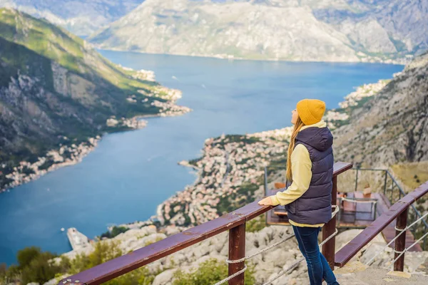 Kadın turist Kotor 'un manzarasından hoşlanıyor. Karadağ. Kotor Körfezi, Kotor Körfezi, Boka Kotorska ve eski şehrin duvarları. Karadağ 'a seyahat. Kotor 'un tahkimatları UNESCO Dünya Mirası' nda — Stok fotoğraf