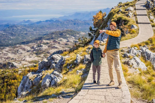 Dad and son travellers in mountain landscape at national park Lovcen, Montenegro. Travel to Montenegro with children concept — Stock Photo, Image