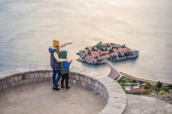Mom and son travelers on background of beautiful view of the island of St. Stephen, Sveti Stefan on the Budva Riviera, Budva, Montenegro. Travel to Montenegro concept. Travel around Montenegro in — ストック写真