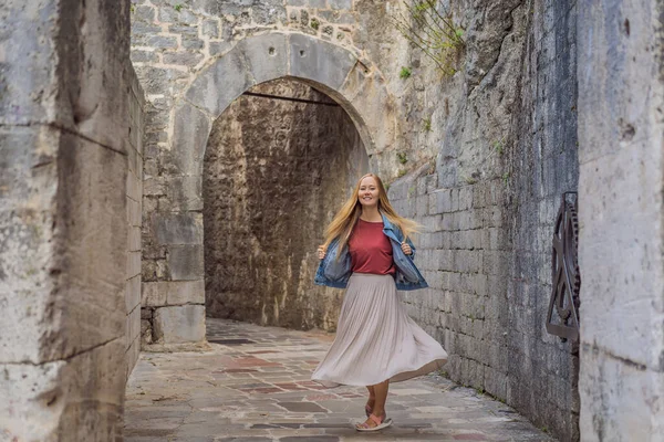 Woman tourist enjoying Colorful street in Old town of Kotor on a sunny day, Montenegro. Travel to Montenegro concept — ストック写真