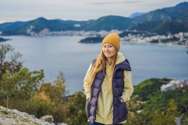Karadağ 'ın dağlarında sıcak giysiler içinde bir kadın. Karadağ 'a bahar, sonbahar, kış aylarında seyahat