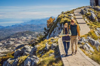Karadağ 'ın Lovcen kentindeki dağ manzarasında bir çift turist ve erkek. Karadağ 'a Seyahat