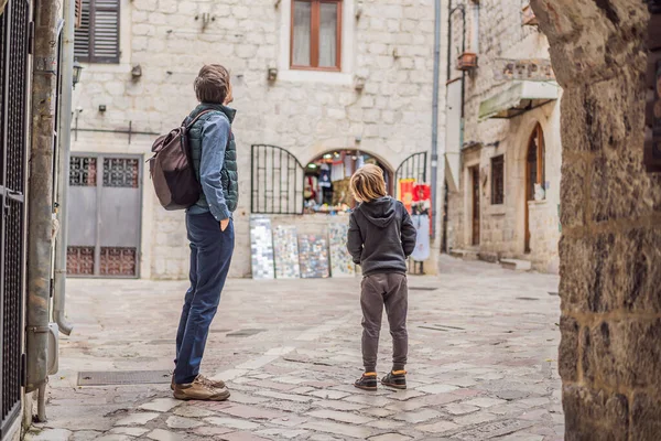 Dad and son travelers enjoying Colorful street in Old town of Kotor on a sunny day, Montenegro. Travel to Montenegro concept — ストック写真