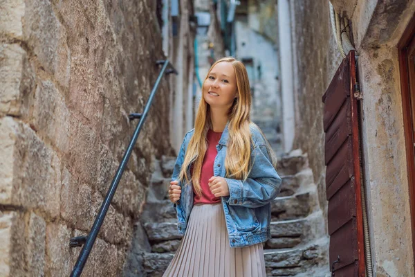 晴れた日にはモンテネグロの旧市街でカラフルな通りを楽しむ女性観光客。モンテネグロのコンセプトへの旅行 — ストック写真