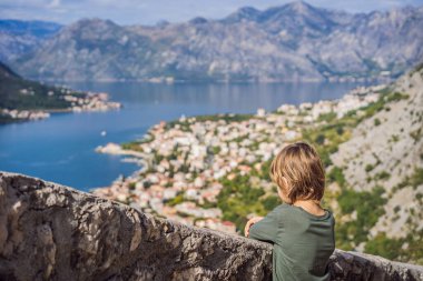 Karadağ 'ın eski Kotor kasabasında güneşli bir günde Renkli caddenin tadını çıkaran erkek turist. Karadağ 'a Seyahat