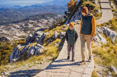 Baba ve oğlu Karadağ 'daki ulusal park Lovcen' de dağ manzarasında gezginler. Karadağ 'a çocuk konseptiyle seyahat
