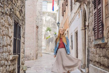 Karadağ 'ın eski Kotor kasabasında güneşli bir günde Renkli Sokak' ın tadını çıkaran kadın turist. Karadağ 'a Seyahat