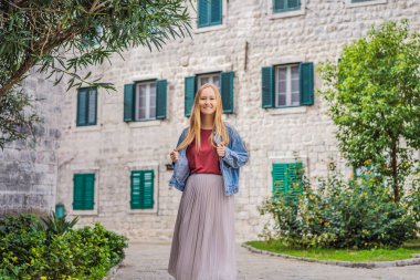 Karadağ 'ın eski Kotor kasabasında güneşli bir günde Renkli Sokak' ın tadını çıkaran kadın turist. Karadağ 'a Seyahat