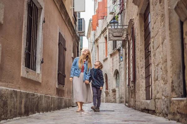 Mamma och son resenärer njuter av färgglada gatan i Gamla stan i Kotor på en solig dag, Montenegro. Resor till Montenegro konceptet — Stockfoto