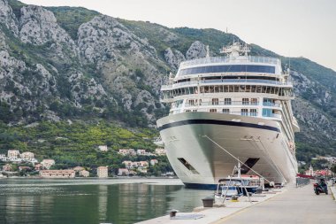 Limandaki yolcu gemisinde. Gün batımında güzel beyaz bir gemi. Marina Körfezi 'nde tekneleri olan renkli bir manzara. Lüks gemi seyahati. Yüzen gemi