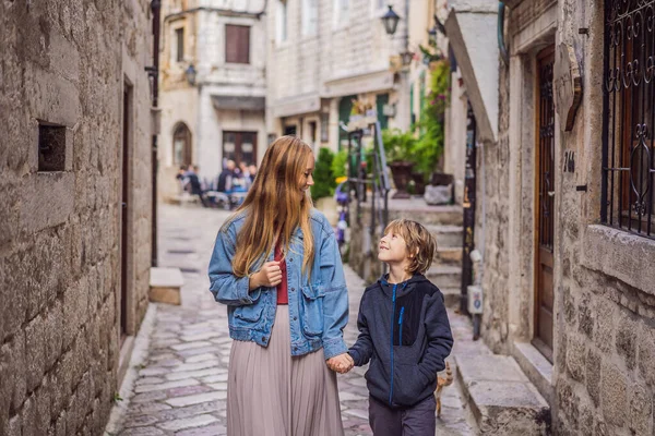 Η μαμά και ο γιος ταξιδιώτες απολαμβάνουν πολύχρωμο δρόμο στην Παλιά πόλη του Κοτόρ σε μια ηλιόλουστη μέρα, Μαυροβούνιο. Ταξίδι στο Μαυροβούνιο — Φωτογραφία Αρχείου