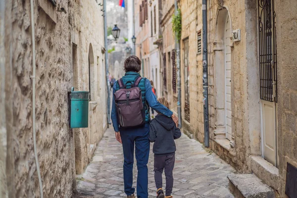Dad and son travelers enjoying Colorful street in Old town of Kotor on a sunny day, Montenegro. Travel to Montenegro concept — стоковое фото