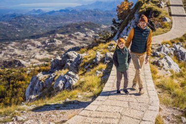 Baba ve oğlu Karadağ 'daki ulusal park Lovcen' de dağ manzarasında gezginler. Karadağ 'a çocuk konseptiyle seyahat