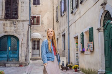 Karadağ 'ın eski Kotor kasabasında güneşli bir günde Renkli Sokak' ın tadını çıkaran kadın turist. Karadağ 'a Seyahat