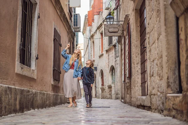 Mamma och son resenärer njuter av färgglada gatan i Gamla stan i Kotor på en solig dag, Montenegro. Resor till Montenegro konceptet — Stockfoto