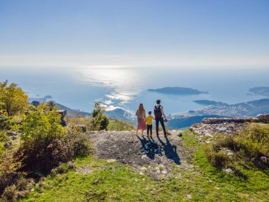Karadağ 'ın Budva kentinin Panoramik manzarasının arka planında mutlu bir aile var. Dağlardan Adriyatik Denizi 'ne güzel bir manzara