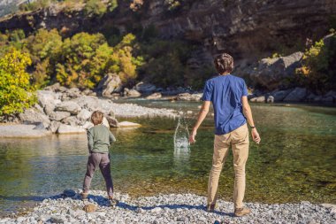 Karadağ. Baba ve oğul turistler, Moraca nehrinin temiz turkuaz suyunun arka planında yeşil moraca kanyonu doğa manzarasında. Karadağ 'da seyahat kavramı