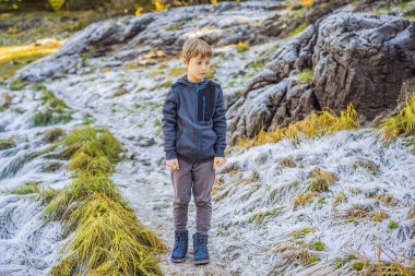 Çocuk yeşil çimlerin üzerine düşen ilk kara şaşırır.