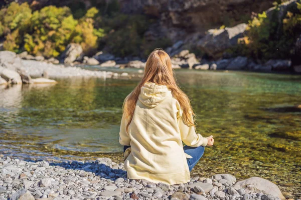 Montenegro. Woman tourist meditates on the background of Clean clear turquoise water of river Moraca in green moraca canyon nature landscape. Travel around Montenegro concept — Foto de Stock