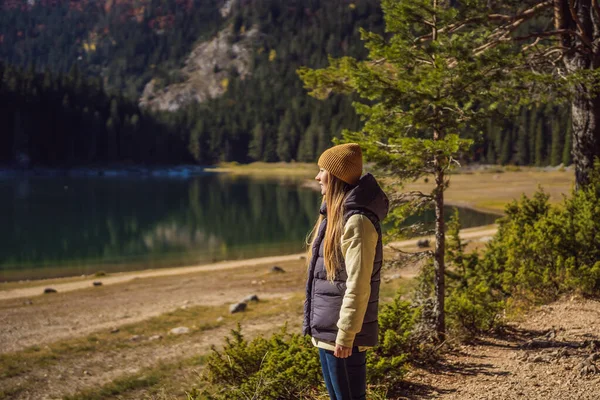 Woman tourist in background of Panoramic morning view of Black Lake Crno Jezero. Calm summer scene of Durmitor Nacionalni Park, Zabljak location, Montenegro, Europe. Beauty of nature concept — Foto de Stock