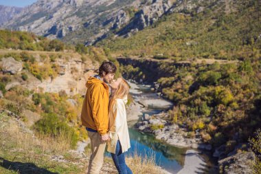 Karadağ. Moraca Nehri 'nin temiz turkuaz suyu ve yeşil Moraca Kanyonu doğa manzarasının arka planında mutlu çift ve kadın turistler. Karadağ 'da seyahat kavramı