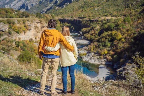 Montenegro. Happy couple man and woman tourists on the background of Clean clear turquoise water of river Moraca in green moraca canyon nature landscape. Travel around Montenegro concept — 스톡 사진