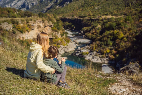 Karadağ. Anne ve oğul turistler, Moraca nehrinin temiz turkuaz suyunun arka planında yeşil moraca kanyonu doğa manzarasında. Karadağ 'da seyahat kavramı