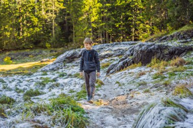Çocuk yeşil çimlerin üzerine düşen ilk kara şaşırır.