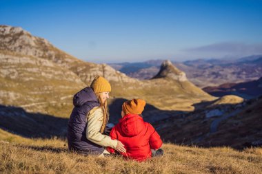 Karadağ. Anne ve oğul turistler Durmitor Ulusal Parkı 'nın arka planında. Eyer Geçidi. Alp çayırları. Dağ manzarası. Karadağ 'da seyahat kavramı