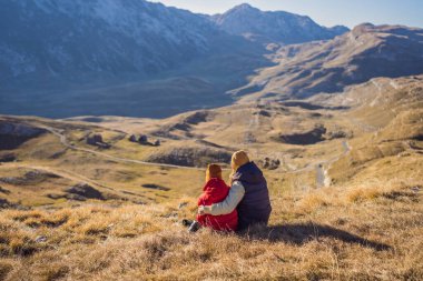 Karadağ. Anne ve oğul turistler Durmitor Ulusal Parkı 'nın arka planında. Eyer Geçidi. Alp çayırları. Dağ manzarası. Karadağ 'da seyahat kavramı
