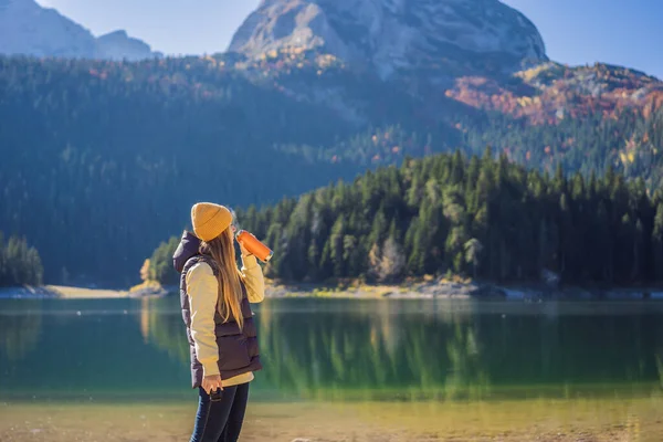 Woman tourist in background of Panoramic morning view of Black Lake Crno Jezero. Calm summer scene of Durmitor Nacionalni Park, Zabljak location, Montenegro, Europe. Beauty of nature concept — Foto de Stock