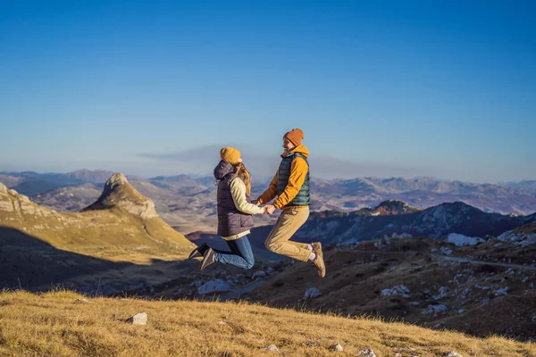 Karadağ. Durmitor Ulusal Parkı 'nın arka planında mutlu çift kadın ve erkek turistler. Eyer Geçidi. Alp çayırları. Dağ manzarası. Karadağ 'da seyahat kavramı — Stok fotoğraf