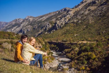 Karadağ. Moraca Nehri 'nin temiz turkuaz suyu ve yeşil Moraca Kanyonu doğa manzarasının arka planında mutlu çift ve kadın turistler. Karadağ 'da seyahat kavramı