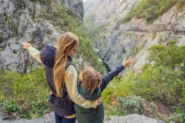 Anne ve oğul turistler kışın Moraca Nehri 'nin Güzel Kanyonu' nun arka planında, Karadağ veya Crna Gora, Balkan, Avrupa