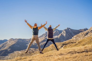 Karadağ. Durmitor Ulusal Parkı 'nın arka planında mutlu çift kadın ve erkek turistler. Eyer Geçidi. Alp çayırları. Dağ manzarası. Karadağ 'da seyahat kavramı