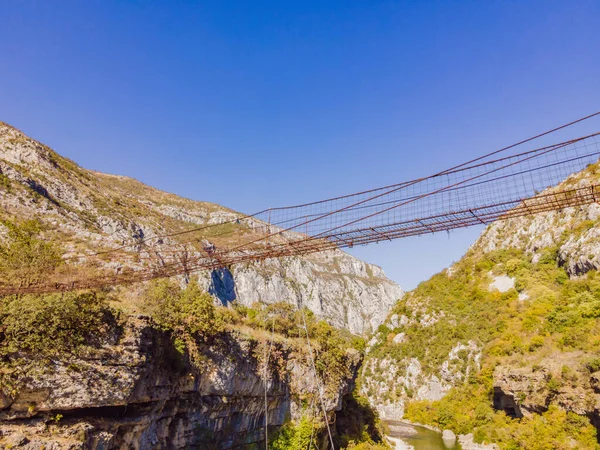 Sights of Montenegro. Landmark Old rusty bridge. Attraction Long extreme suspension iron bridge across the river Moraca. Montenegro — Foto Stock