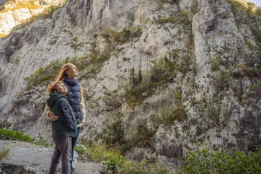 Anne ve oğul turistler kışın Moraca Nehri 'nin Güzel Kanyonu' nun arka planında, Karadağ veya Crna Gora, Balkan, Avrupa