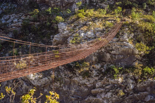 Sehenswürdigkeiten von Montenegro. Wahrzeichen Alte rostige Brücke. Attraktion Lange extreme Eisenhängebrücke über den Fluss Moraca. Montenegro — Stockfoto