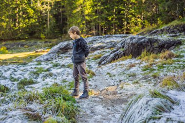 Çocuk yeşil çimlerin üzerine düşen ilk kara şaşırır.