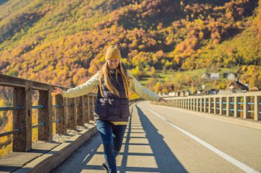 Karadağ. Tara Nehri üzerindeki Dzhurdzhevich Köprüsü 'nün arka planında sisli bir sabah geçiren bir kadın turist. Karadağ 'da seyahat etmek. Karadağ manzarası