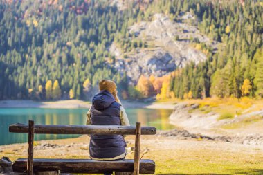 Kara Göl Crno Jezero 'nun Panoramik Sabah Görüşü' nün arka planındaki kadın turist. Durmitor Nacionalni Park 'ın sakin yaz manzarası, Zabljak konumu, Karadağ, Avrupa. Doğanın güzelliği konsepti
