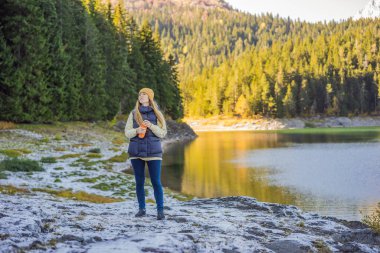 Kara Göl Crno Jezero 'nun Panoramik Sabah Görüşü' nün arka planındaki kadın turist. Durmitor Nacionalni Park 'ın sakin yaz manzarası, Zabljak konumu, Karadağ, Avrupa. Doğanın güzelliği konsepti