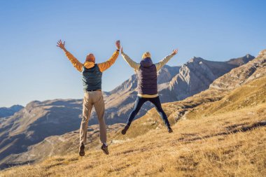 Karadağ. Durmitor Ulusal Parkı 'nın arka planında mutlu çift kadın ve erkek turistler. Eyer Geçidi. Alp çayırları. Dağ manzarası. Karadağ 'da seyahat kavramı