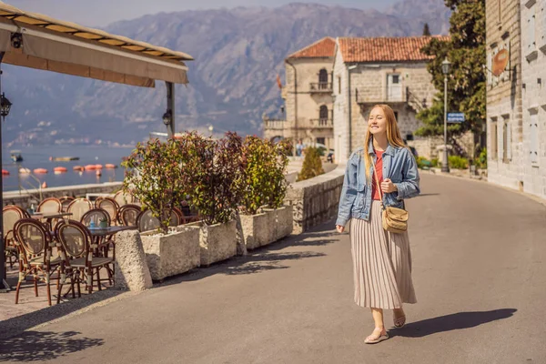 Mulher turista desfrutando Colorful rua na cidade velha de Perast em um dia ensolarado, Montenegro. Viajar para Montenegro conceito. Vista panorâmica panorâmica da cidade histórica de Perast na famosa Baía de Kotor em um — Fotografia de Stock