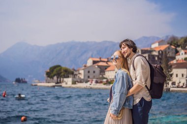 Aşık mutlu çift ve kadın turistler güneşli bir günde Eski Perast kasabasında renkli caddelerin tadını çıkarıyorlar. Karadağ 'a seyahat. Tarihi Perast kasabasının manzara manzarası